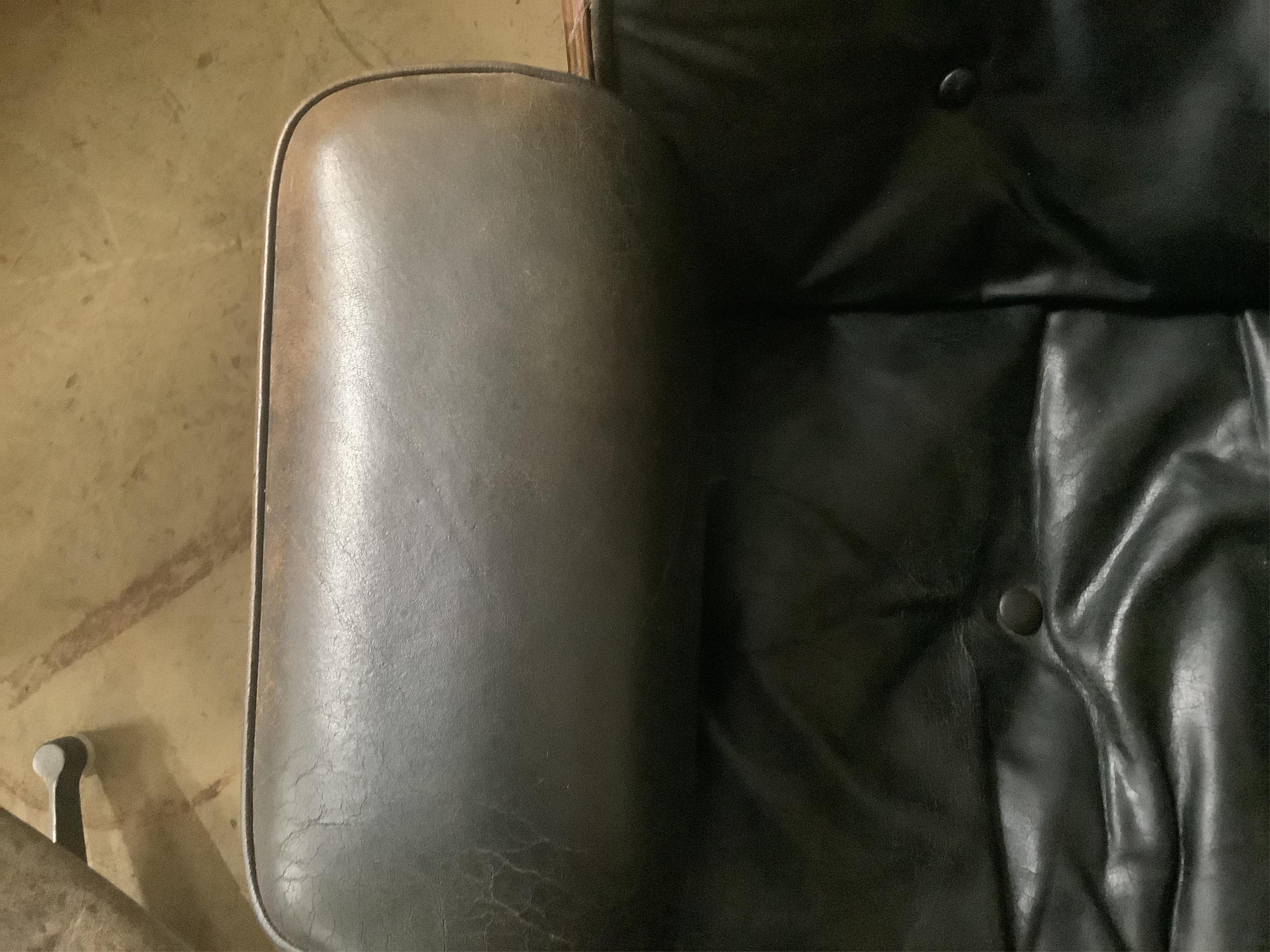 Charles and Ray Eames for Herman Miller Interform, an Indian rosewood and black leather lounge chair and ottoman, circa 1960, chair width 85cm, depth 68cm, height 81cm. Condition - poor to fair